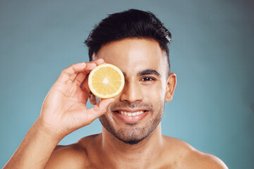 Happy studio portrait, man lemon skincare for beauty wellness and face health against blue...