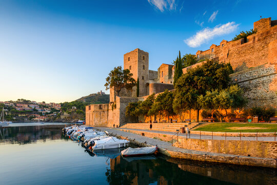 Medieval castle and boats at Collioure city at sunrise in France