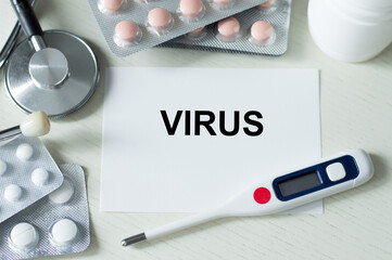 virus text on card on the table next to the termgometer and tablets