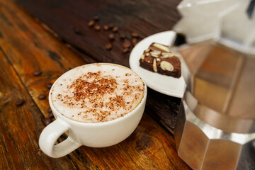 Hot cappuccino in white cup with wooden background,coffee is a popular drink all over the world.
