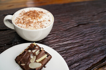 Hot cappuccino in white cup with wooden background,coffee is a popular drink all over the world.