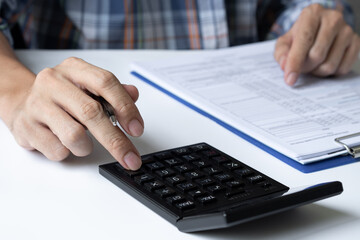 close up. business man working on his desk using a calculator to calculate numbers financial accounting concept.