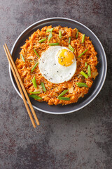 Kimchi fried rice with egg Bokkeumbap concept for Korean food and menu closeup on the plate on the table. Vertical top view from above