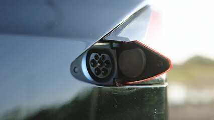 Type 2 plug port on electric vehicle. Fast charging socket type 2 electric car. DC - type 2 EV charging connector at EV car. Eco friendly alternative energy green environment concept.