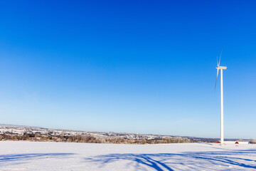 Wind turbine on a snowy field with a beautiful view