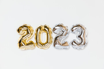 New year 2023 balloon celebration card. Gold and silver foil helium balloon number 2023 isolated on white background. Flat lay, merry christmas, happy holidays mockup.
