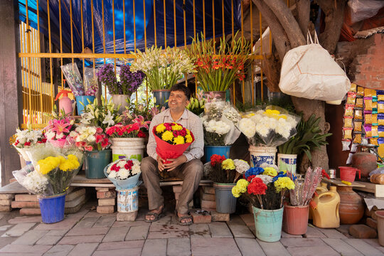 Male florist sitting at his shop with a flower bouquet