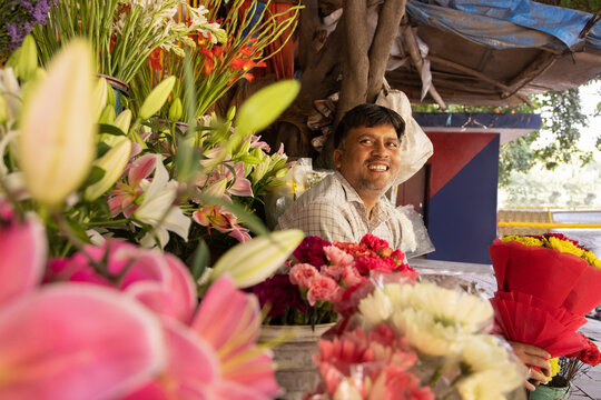 Male florist sitting at his shop with a flower bouquet