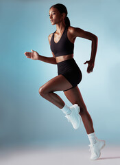 Fitness, health and black woman running in studio with blue background. Sports, exercise and form,...
