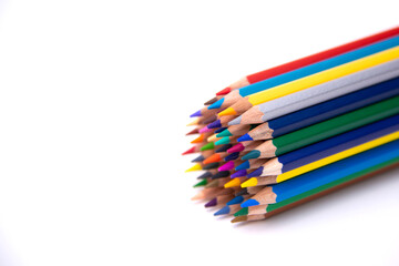 colored pencils of many colors grouped together laid on a white background