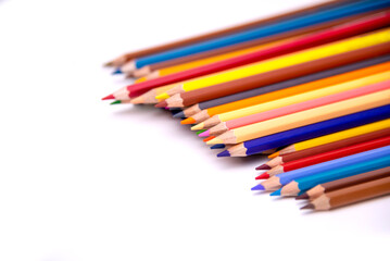 Colors pencils of many colors arranged in a row on a white background 