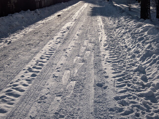 Road covered with compressed snow after heavy snowfall. Accumulation of snow on driving surface in winter. Slippery road conditions