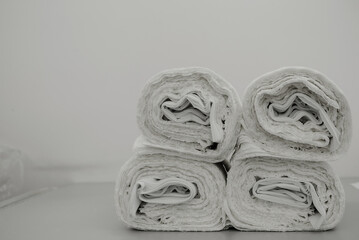 Fototapeta premium rolls of white fabric for sewing a dress at the factory lie on the table; rolls of white fabric for sewing a dress at the factory lie on the table; rolls of fabric lie on top of each other against a 