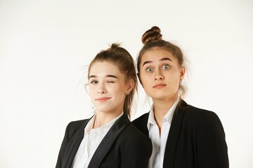 Two girls in office clothes, facial expressions on their faces. Pure white background. The concept of business and corporate relationships in the enterprise.