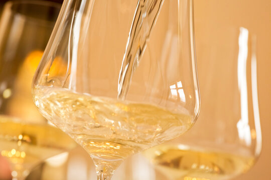 Pouring white wine in a glass in a festive room