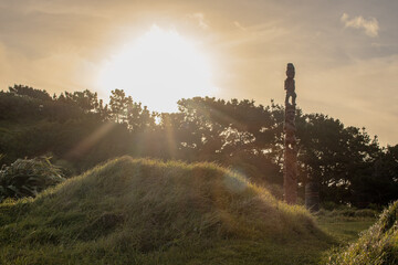 Sunset rays shine over a tall pouwhenua