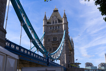 Famous Tower Bridge with traffic and pedestrians at City of London on a blue cloudy summer day. Photo taken August 4th, 2022, London, England.