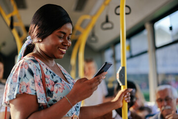 African american woman looking at smarpthone in public bus