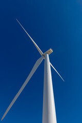 A upward view of a wind turbine from its base.