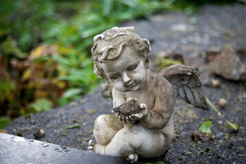 closeup of stoned angel standing on tomb at the cemetery