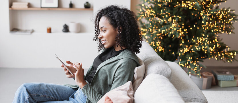 Young woman using smartphone at home during Christmas holiday. Student girl texting on mobile phone banner. Communication, connection, online shopping, winter lifestyle concept