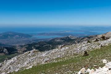 A mountain top view of the landscape below with a panoramic view to infinity.