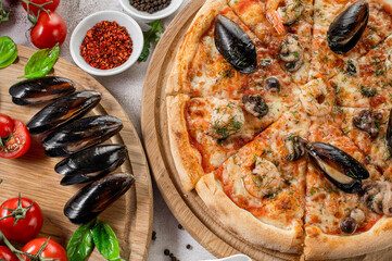 Tasty pizza with a seafood, squids and mussels on the concrete background