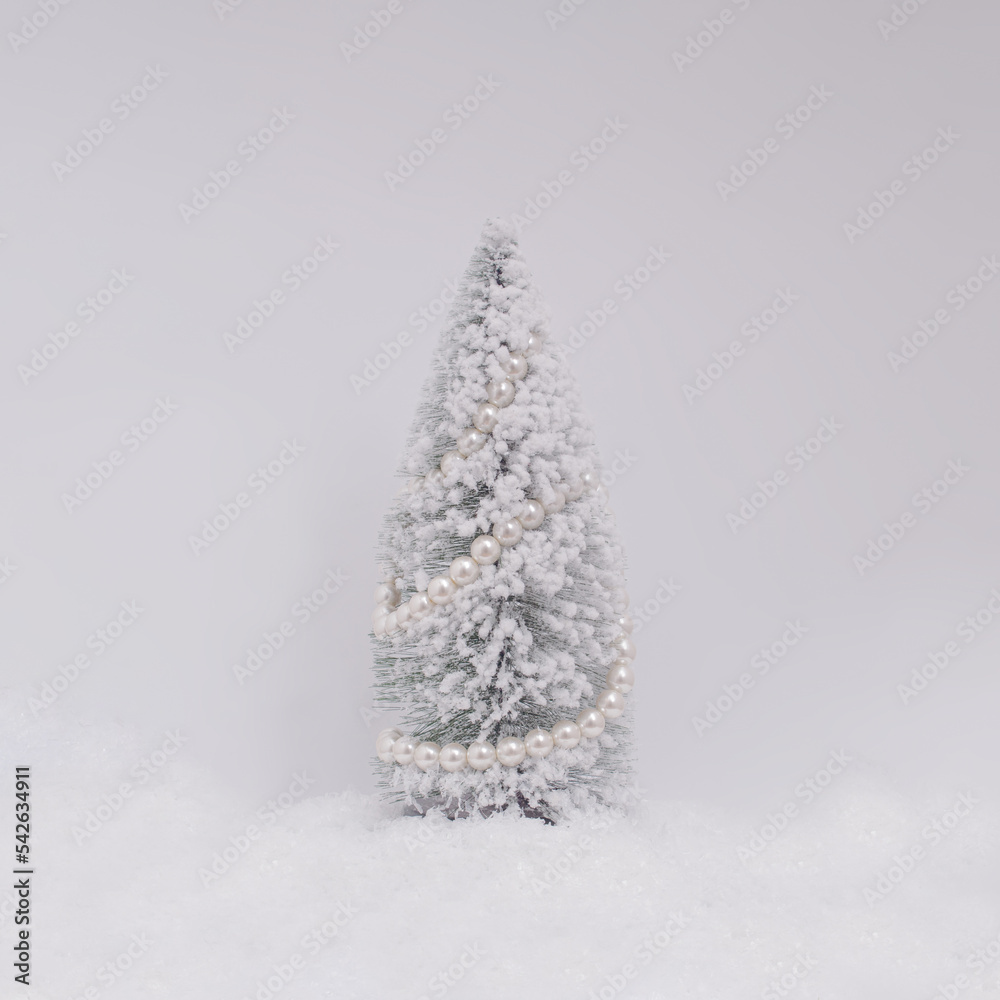 Wall mural christmas or new year layout with white snowy christmas tree and pearls. bright holiday background.