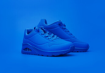 Modern sneakers on blue background. Fashionable stylish leather sports casual shoes. Creative...