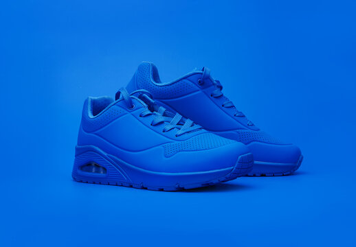 Modern sneakers on blue background. Fashionable stylish leather sports casual shoes. Creative minimalistic footwear layout. Lifestyle product photo, urban style concept.