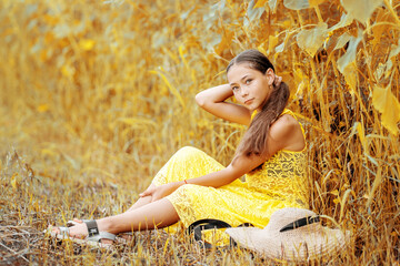 A beautiful girl walks in a sunflower field. A sunny field and a girl.
