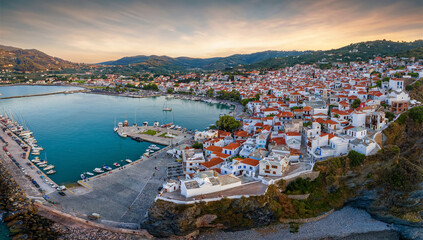 Fototapeta na wymiar Panoramic aerial view of the town of Skopelos island with the traditional, red roofed houses during a calm summer sunset, Sporades, Greece