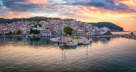 Beautiful, panoramic view of the city and harbour of Skopelos island, Sporades, Greece, during a golden summer sunset