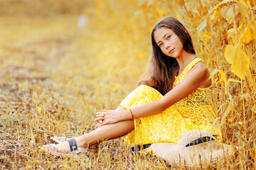 A beautiful girl walks in a sunflower field. A sunny field and a girl.