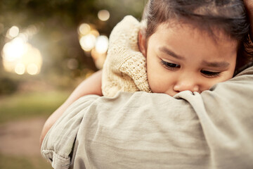 Hug, park and sad girl with parent for comfort, care and support while outdoors in nature. Family,...