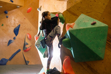 bouldering, little girl climbing up the wall