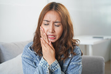 woman touching her cheek because feeling tooth pain