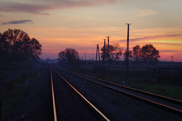 Kolorowe niebo po zachodzie słońca nad torami kolejowymi. - obrazy, fototapety, plakaty