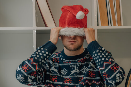 Young Man Or Teenager In Christmas At Home Angry With Santa Claus Hat