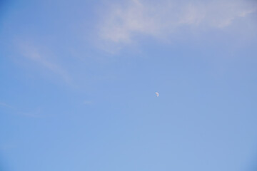 The moon rises during the day, the area is brightly colored.