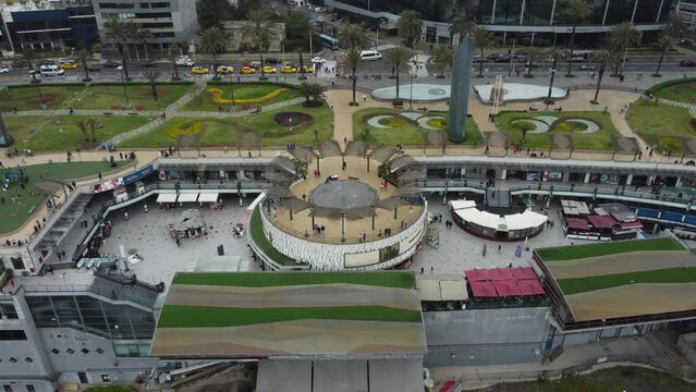 Drone 4k video of a shopping center called "Larcomar" in the Miraflores district of Lima, Peru. Drone flies  backwards and upwards high above the location situated on the edge of a coastal hill.