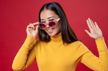Joyful brunette posing for the camera against the red background