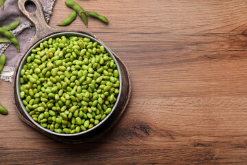 Organic edamame beans on wooden table, flat lay. Space for text