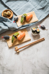 Lachs Avocado Sushi als Nigiri, Maki, roh und knusprig frittiert auf Holz Teller mit Soja Soße in...