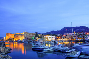 Fototapeta na wymiar Kyrenia marina and yachts at sunset blue hour, boats in the harbor of the town