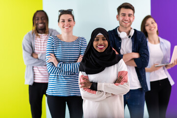 Diverse teenagers using mobile devices while posing for a studio photo in front of a colorful background