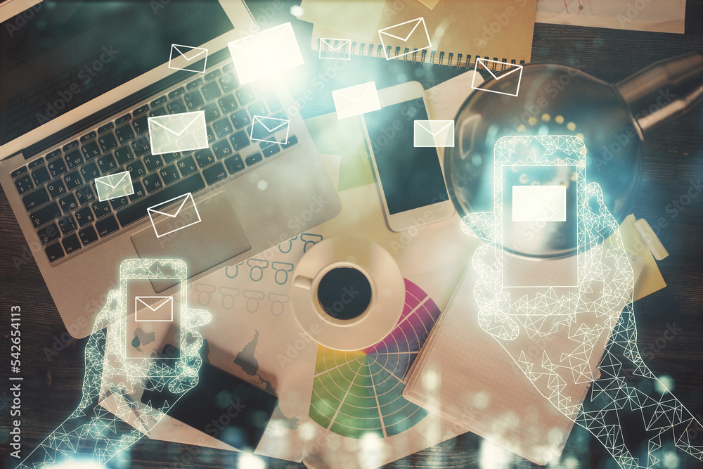 Poster Envelop hologram drawing over computer on the desktop background. Top view. Double exposure. Technology concept.