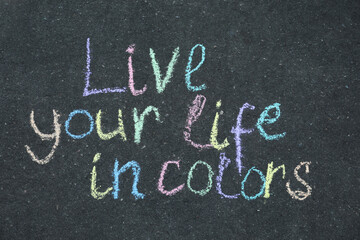Phrase Live Your Life In Colors written on asphalt, top view