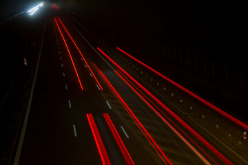 Car light trails at night on a highway seen downwards, long exposure 