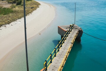 Aerial view of a wooden boardwalk entrance in the sea, Poto Tano Harbour, Sumbawa, Indonesia